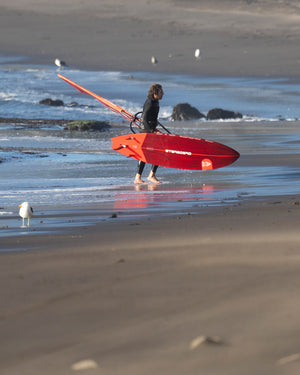 Red Kode Windsurf Board with black fins, leash, fiberglass foam