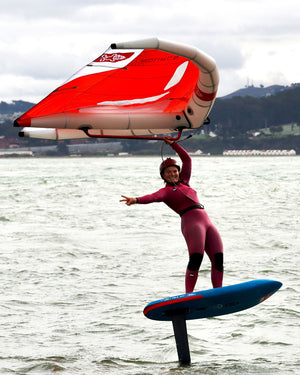 Red and white Source Wing sail with black trim on blue hydrofoil board