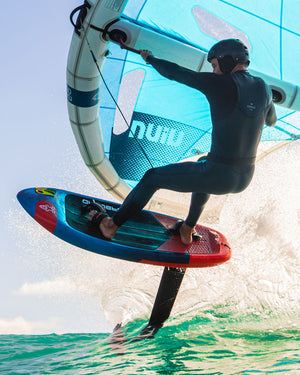 Starboard Viva Wing: Blue and red hydrofoil board with black fins, ridden by windsurfer in wetsuit