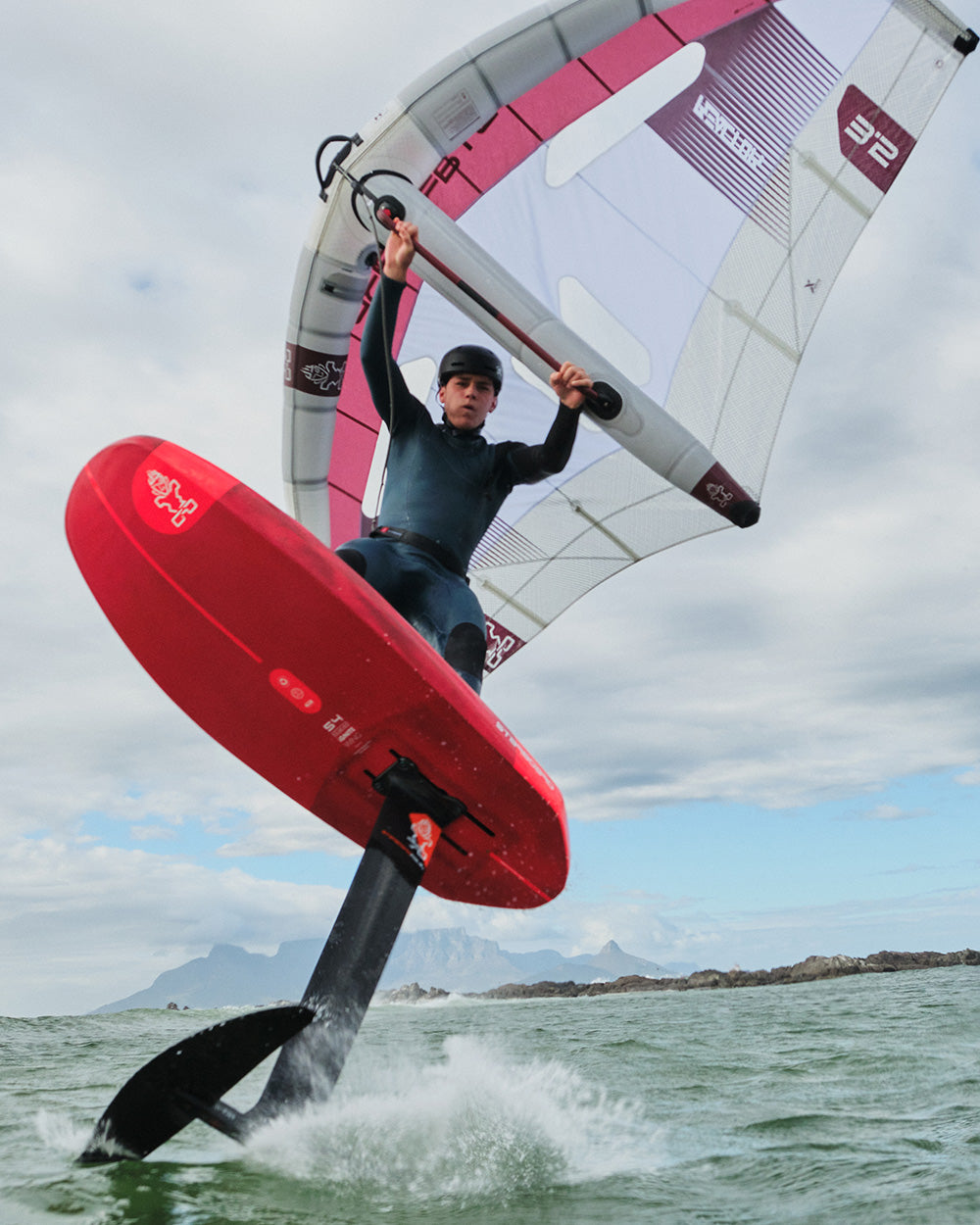 Red iGnite Wing Foilboard with hydrofoil, black fin, white sail, pink accents