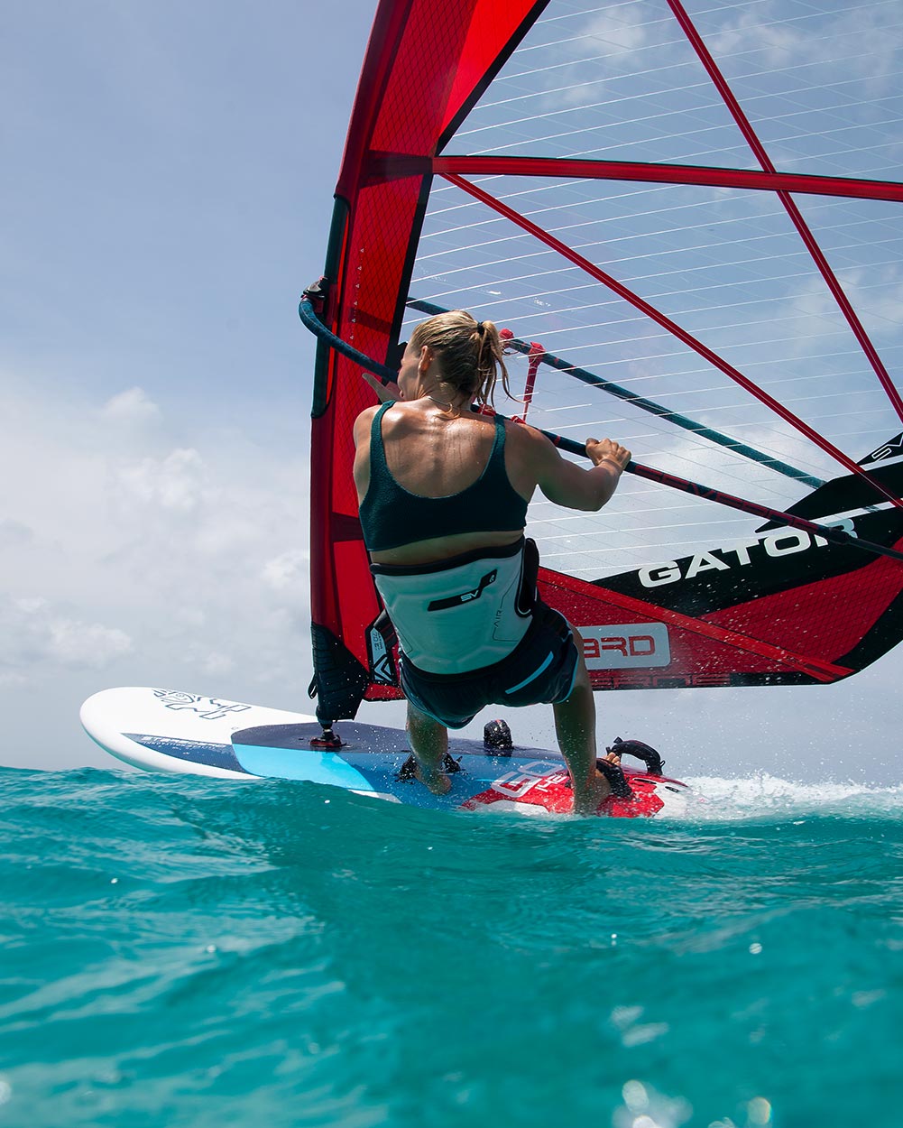 Red and black windsurfing sail with white gato.t text on 2025 GO board