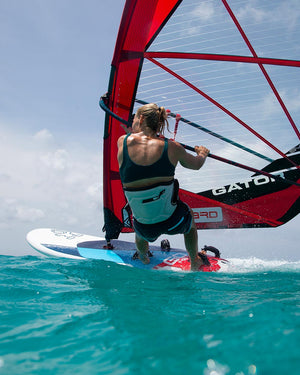 Red and black windsurfing sail with white gato.t text on 2025 GO board
