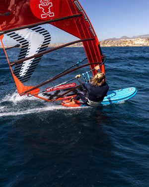 Red and black inflatable windsurf sail with white accents for speed