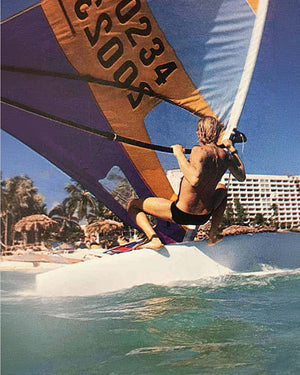 Purple and white Windsurfer LT sail with orange numbers and black trim