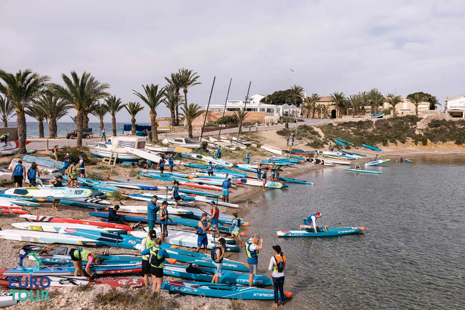 Blue and white fiberglass kayak with red accents at World SUP Festival