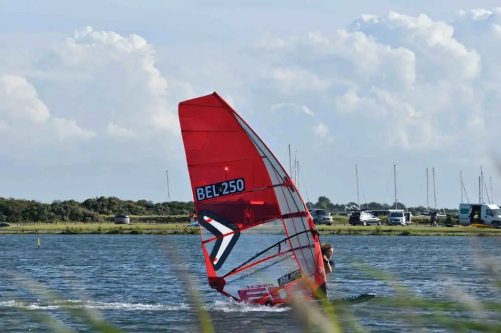 Red and white Bel-250 windsurfing sailboard with black accents for speed under 70kg