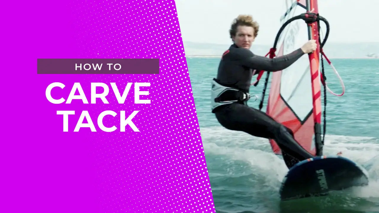 Windsurfer carving tack on red black sail board in blue water