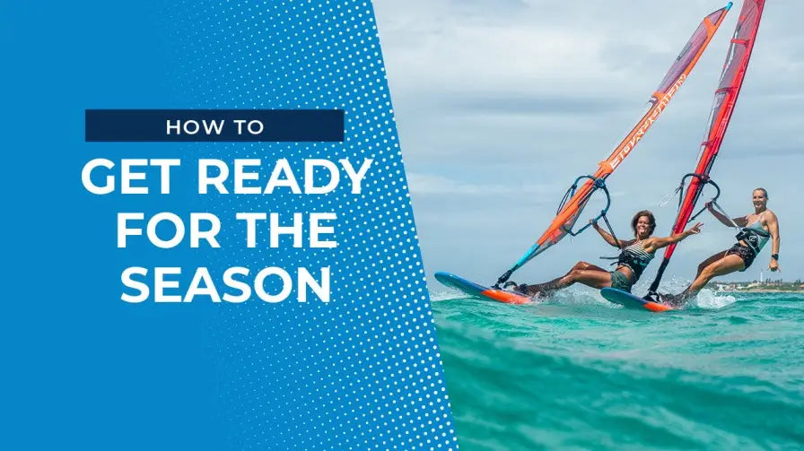 Performance windsurfing board with orange sail and blue fins