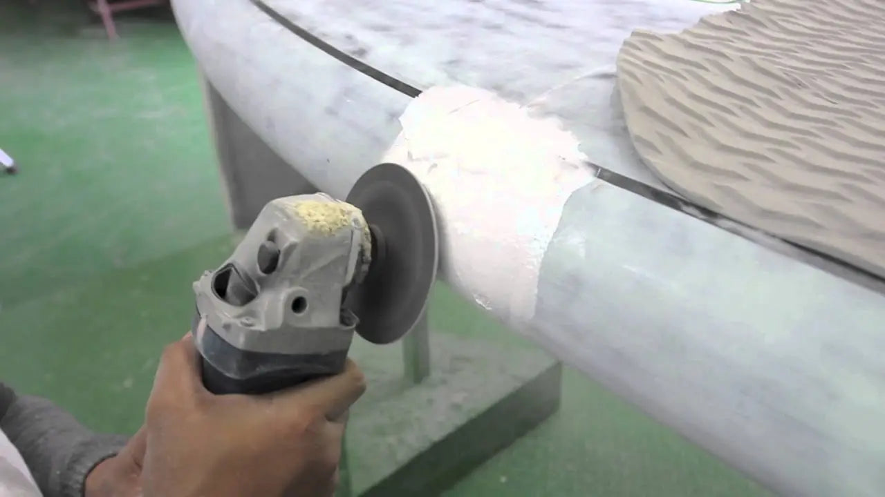 White and gray sanding machine with yellow accents for smoothing paddle board surfaces