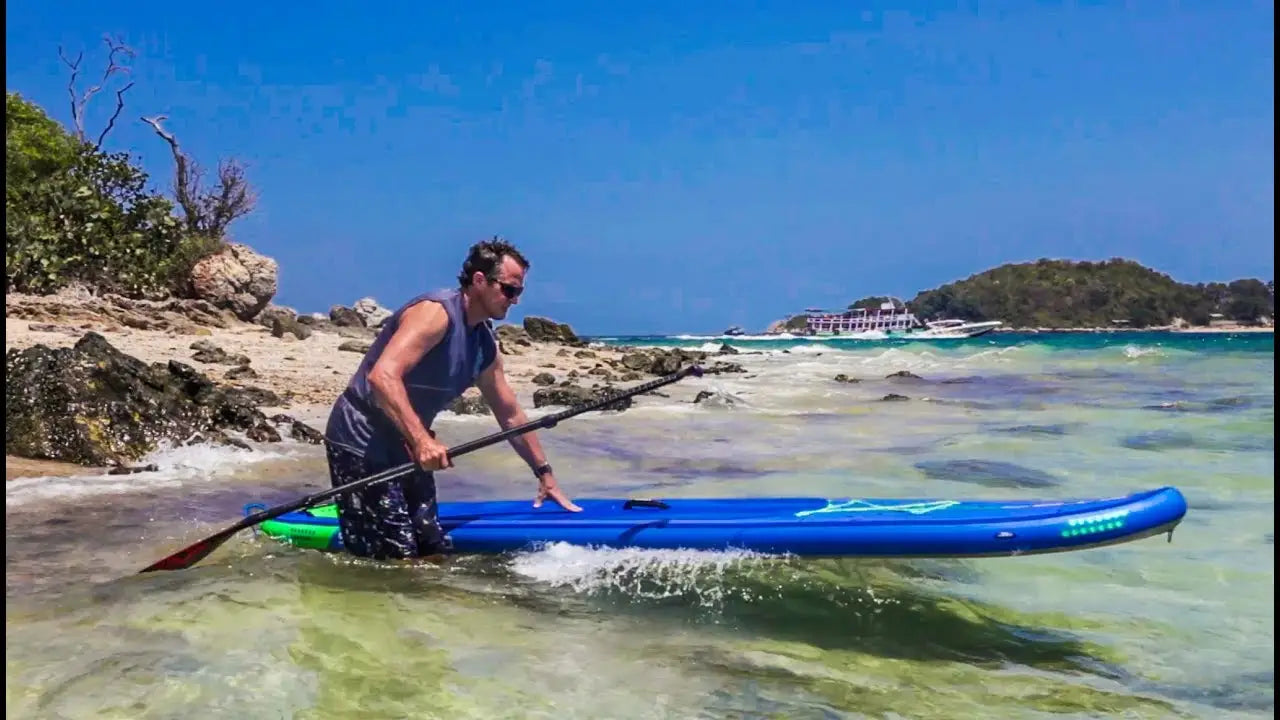 Blue inflatable SUP with black fins and green leash for beginners