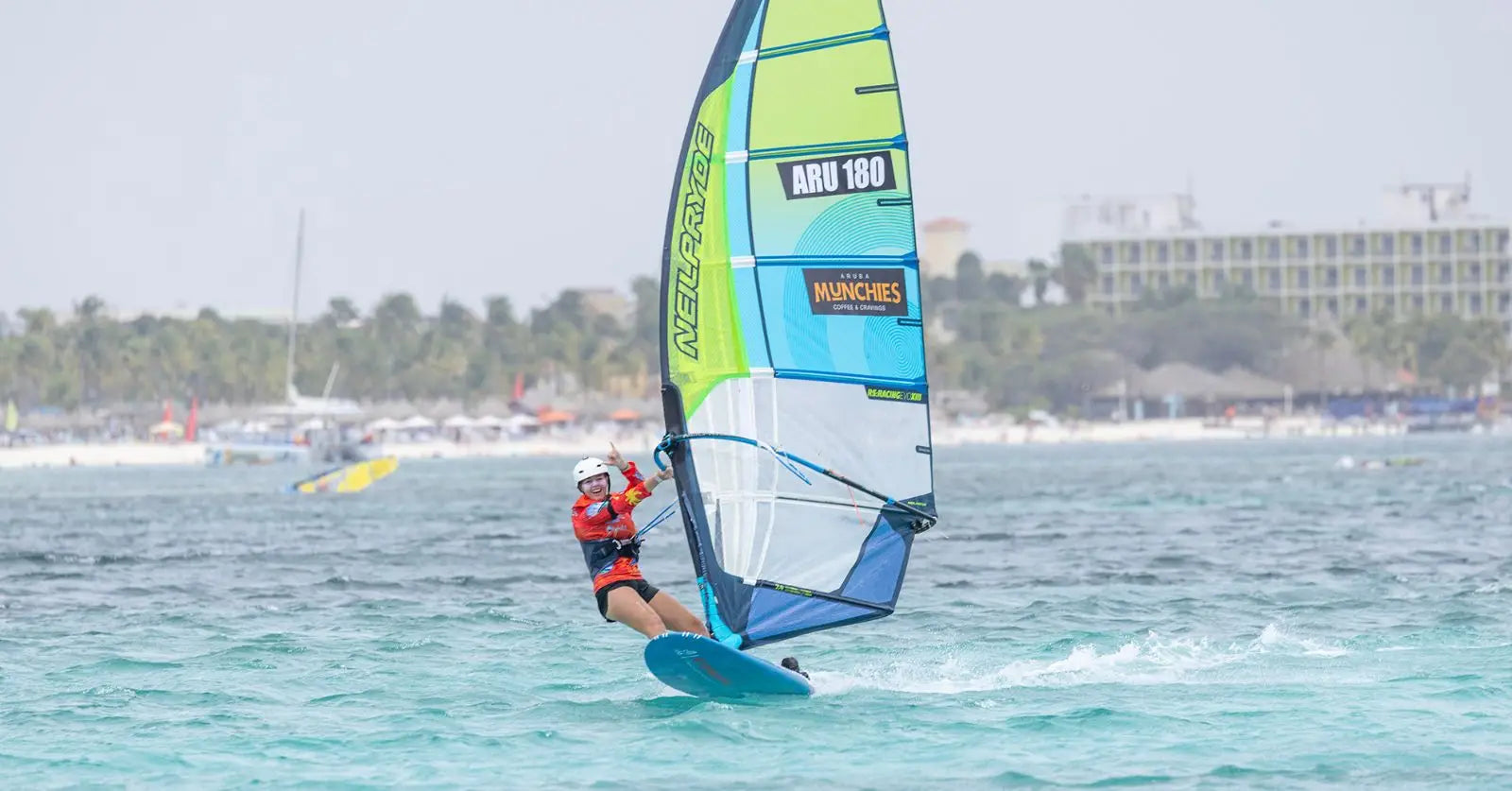 Louise van der Meulen windsurfing with blue-green sail and red harness