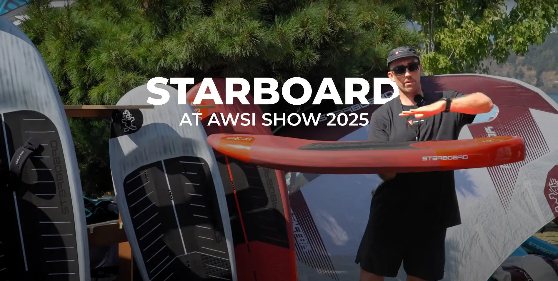 Red and white Starboard surfboard with black fins at AWSI Show 2025