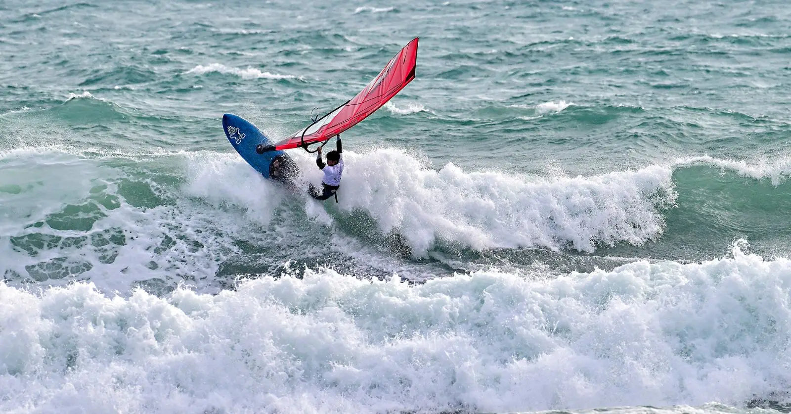 Blue and white Starboard surfboard with red sail at PWA x IWT Japan
