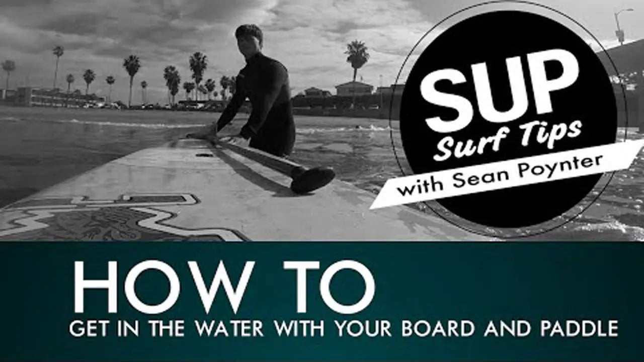 Sleek black and white SUP surfboard with long paddle for wave entry