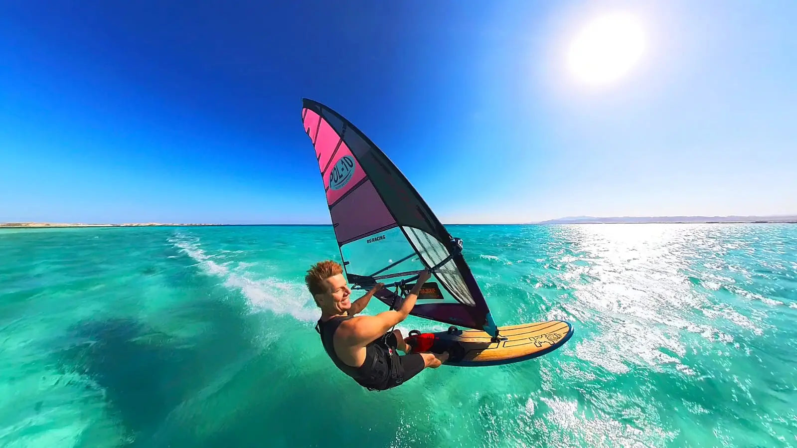 Pink and black nylon windsurfing sail with yellow trim by Wojtek Brzozowski