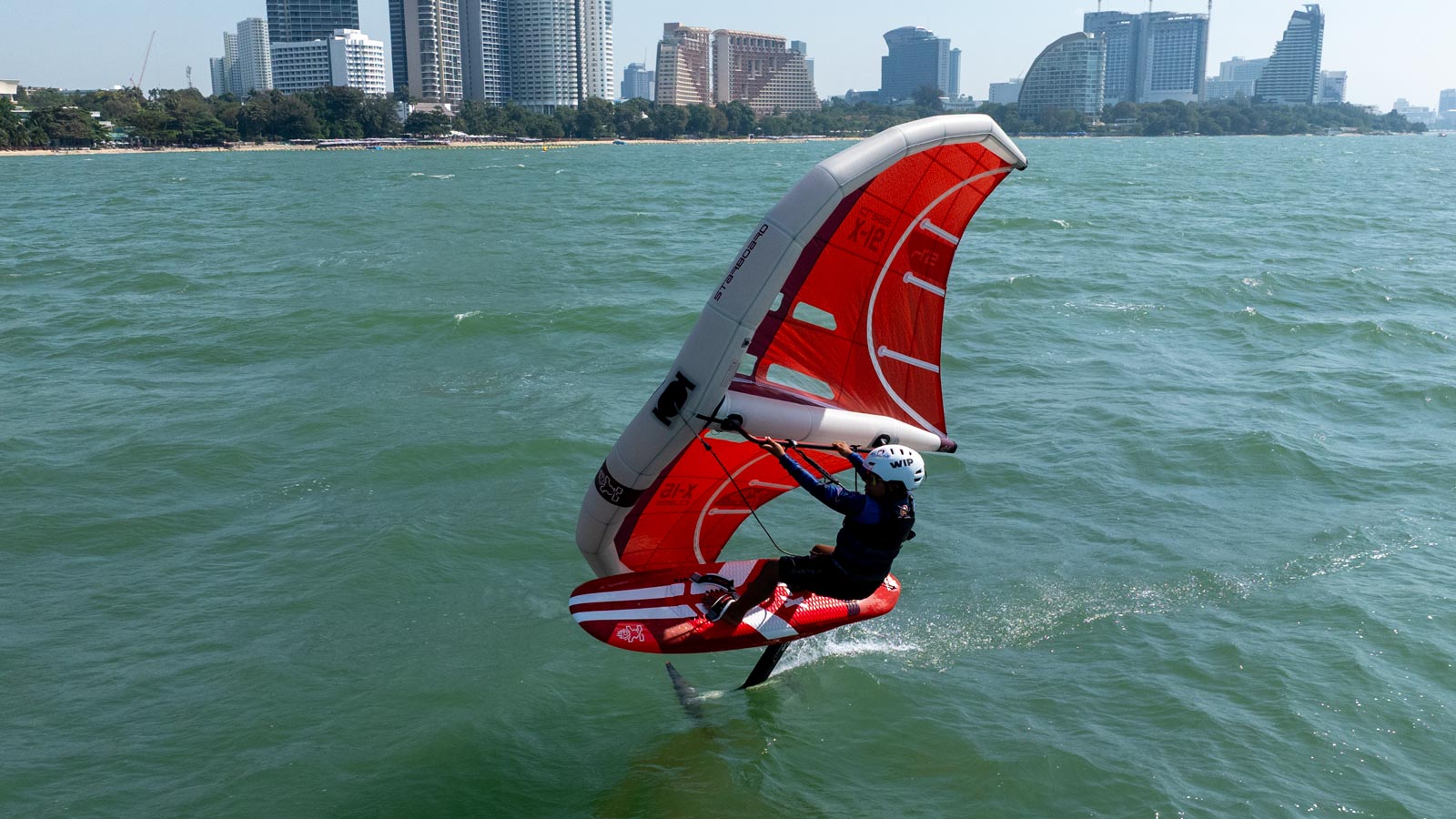 Red and white kiteboarding board with large sail in Race Wingfoil collection