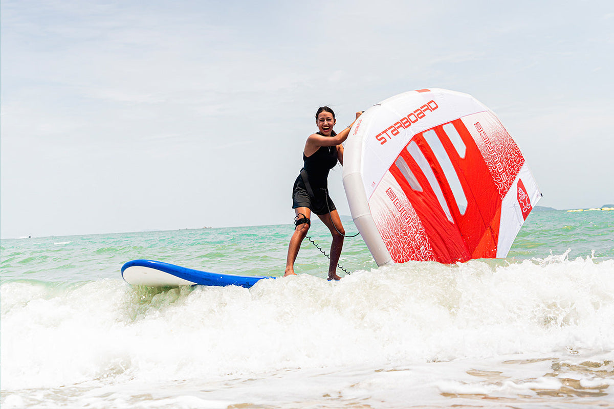 Red and white windsurfing sail with blue trim in Entry-Level Wingboards