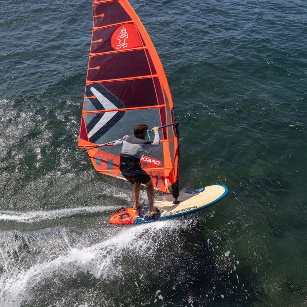 Orange Carve Windsurf Board with black and white sail for water sports.