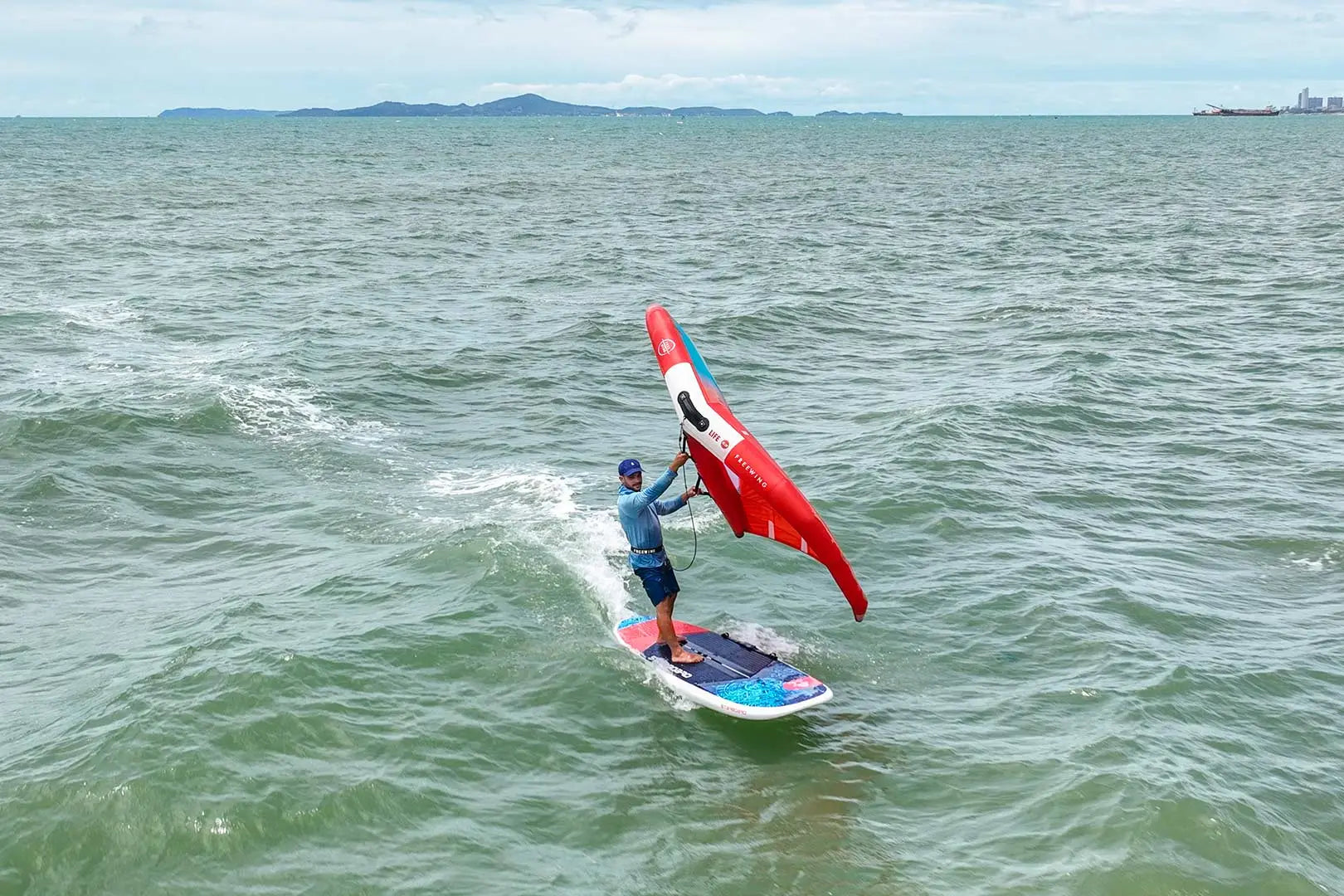 Red and white sailboat with blue trim in Crossover Boards