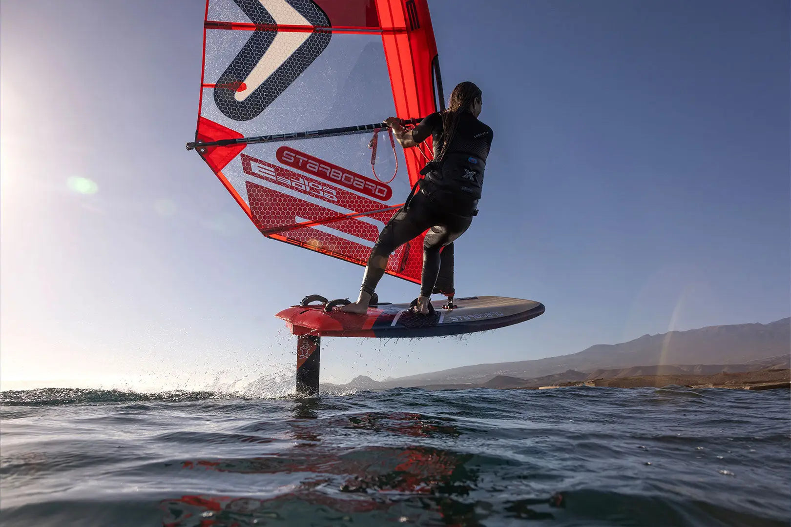 Red and white hydrofoil board with black accents for high-performance freeride windfoiling