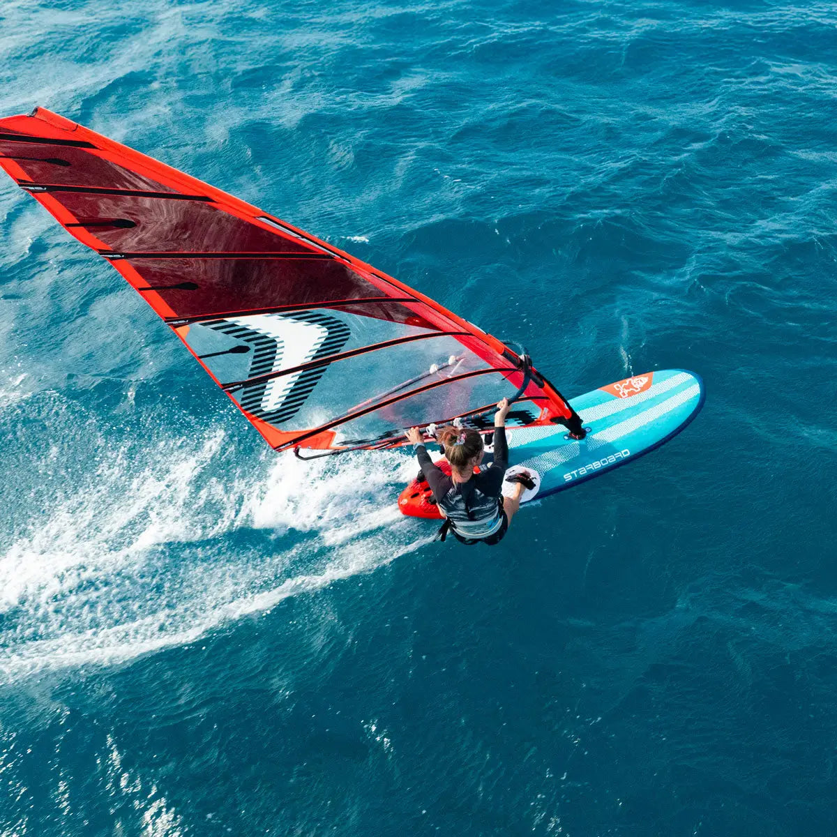 Red and black freeride windsurfing sail with white accents in durable nylon