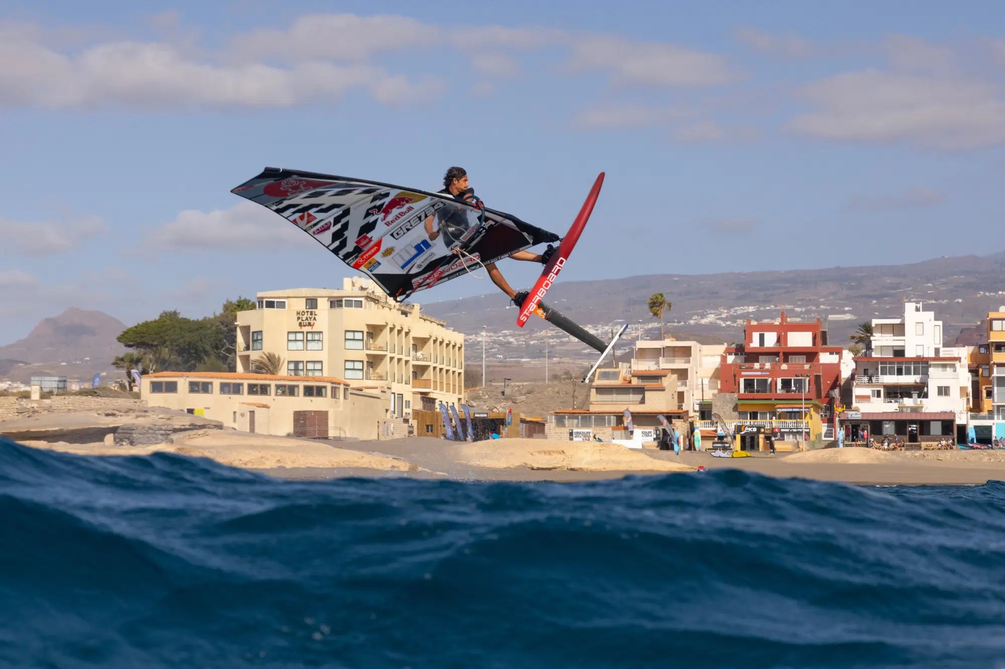 Freestyle windfoil board with red and white carbon fiber design