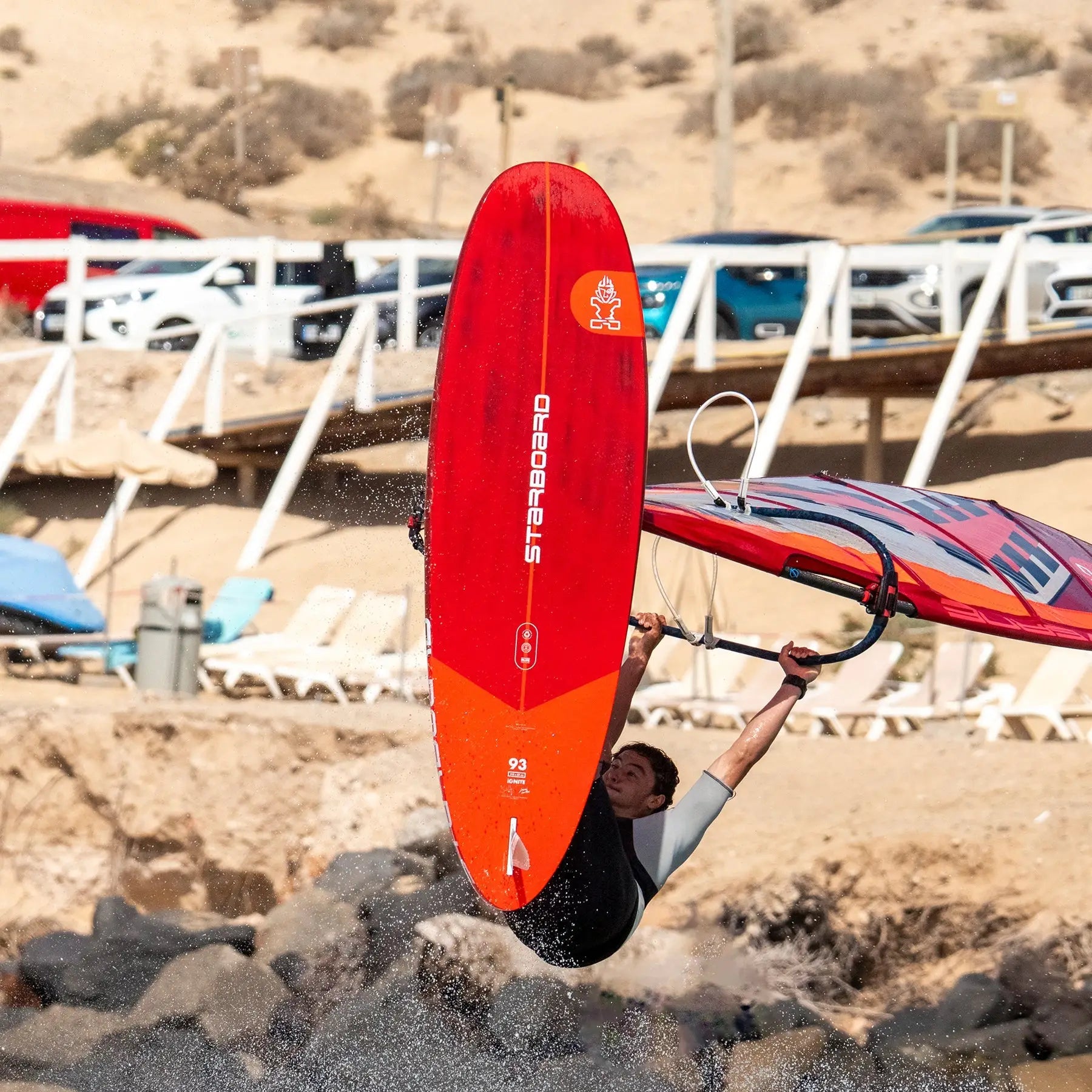 Red freestyle windsurfing board with white and yellow accents