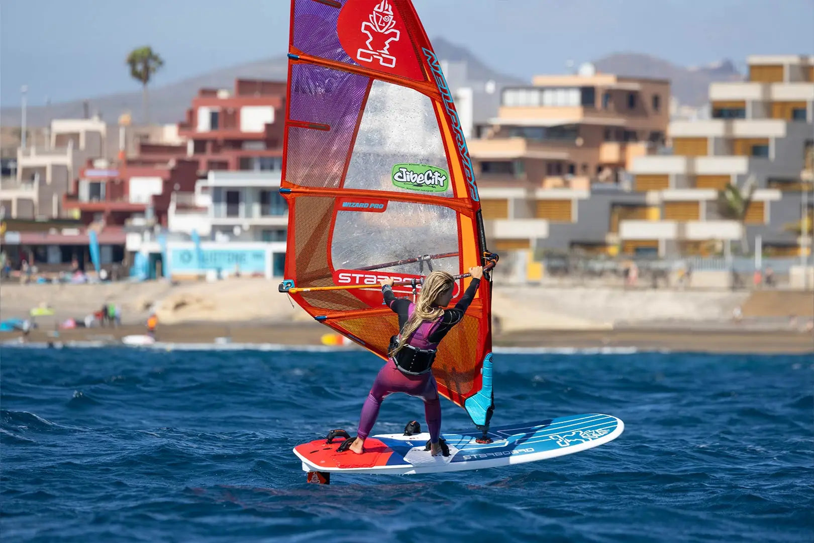 GO Fly Windfoil Boards: Red and blue windsurfing board with orange sail