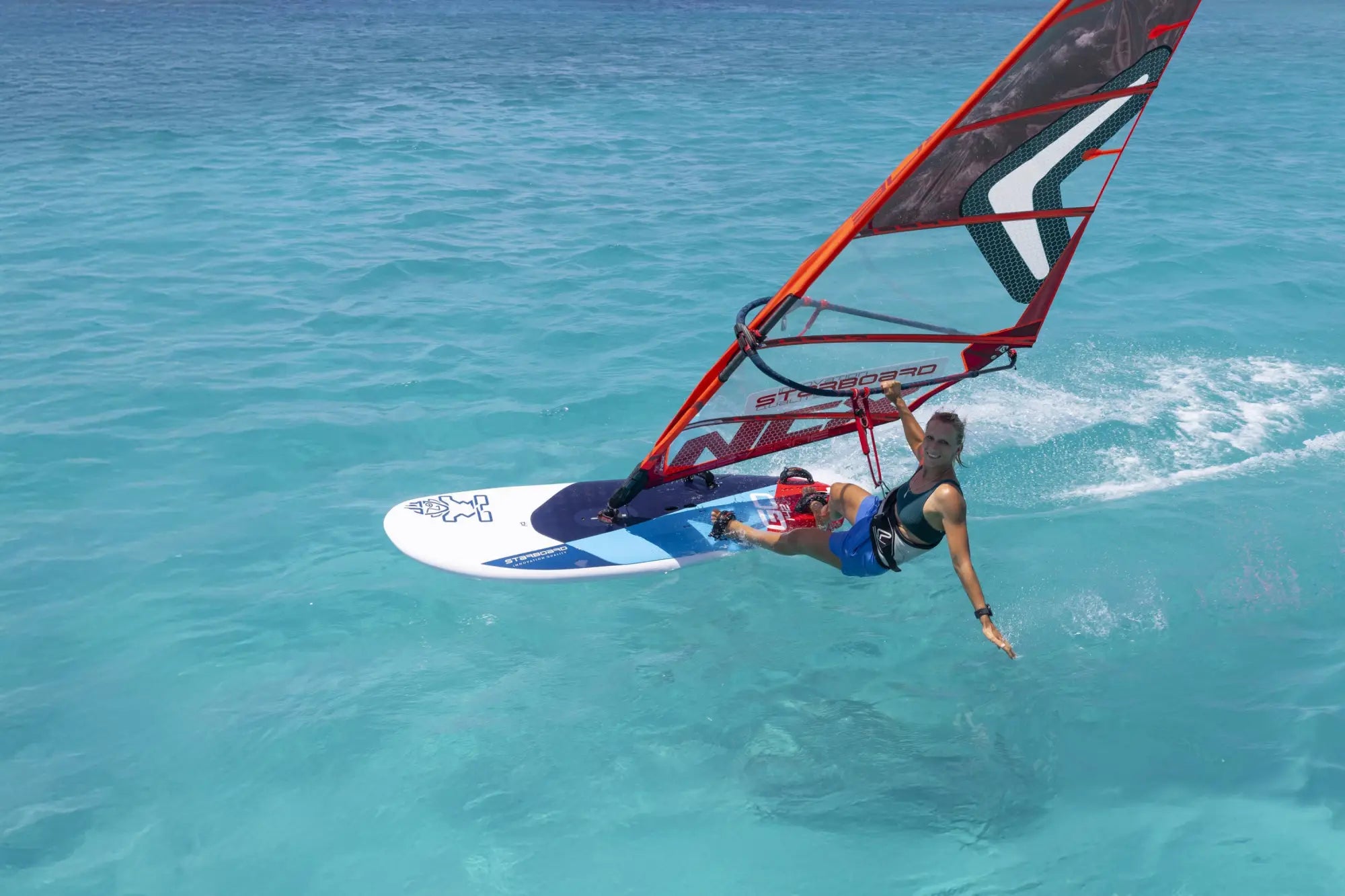 GO Windsurf Board with red white sail and sleek blue black harness design