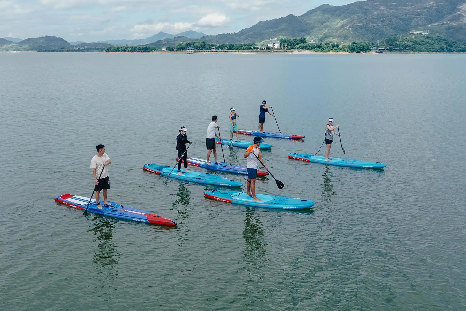 Blue and red inflatable paddleboard with white paddles