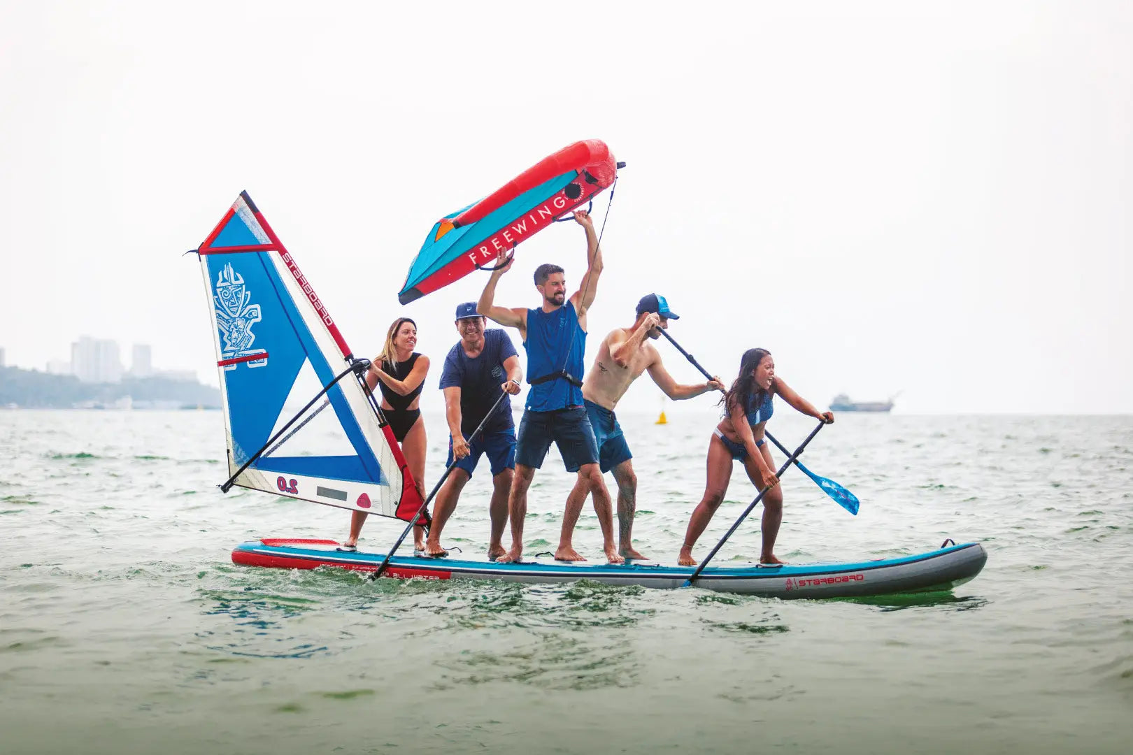 Colorful inflatable paddleboard with built-in sail for multi-person use