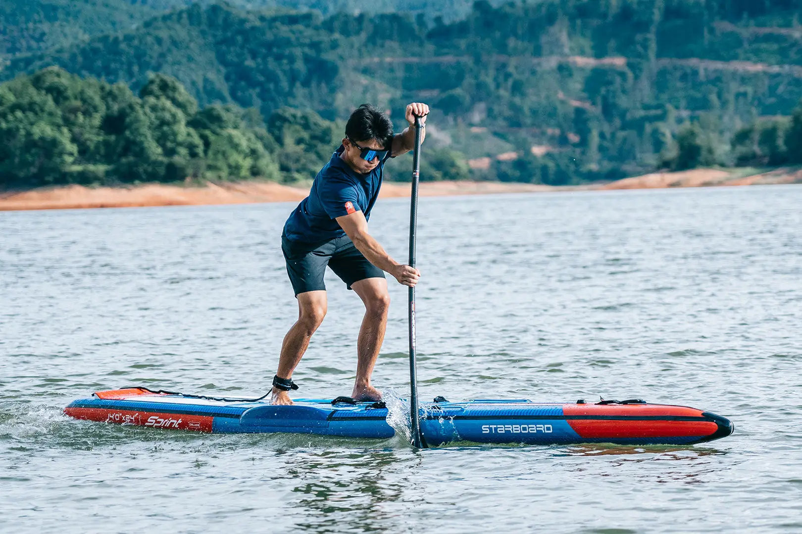 Blue and red inflatable race paddleboard with non-slip deck