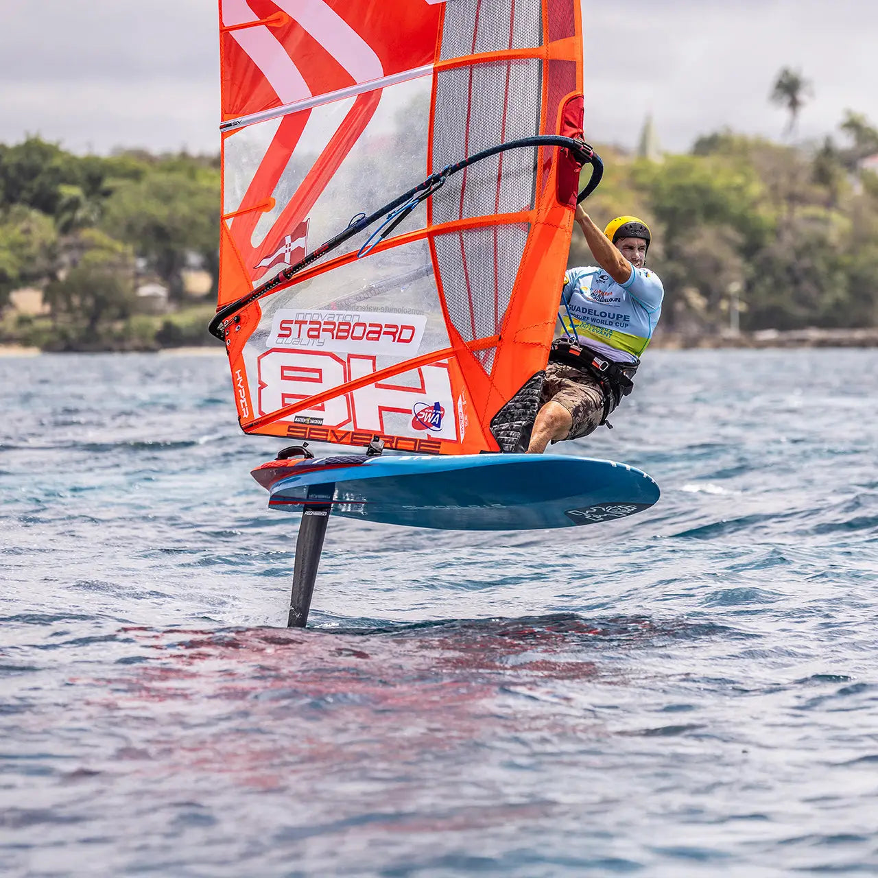 Orange starboard hydrofoil sailboat with blue trim in Race Windfoil
