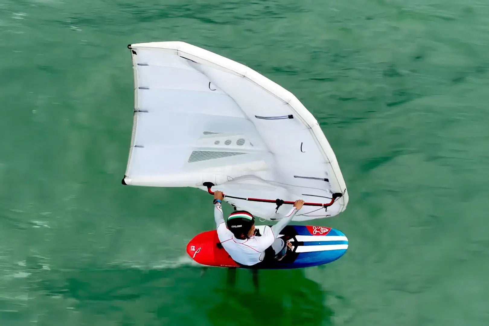 Red and white kiteboarding board with large sail in Race Wingfoil collection