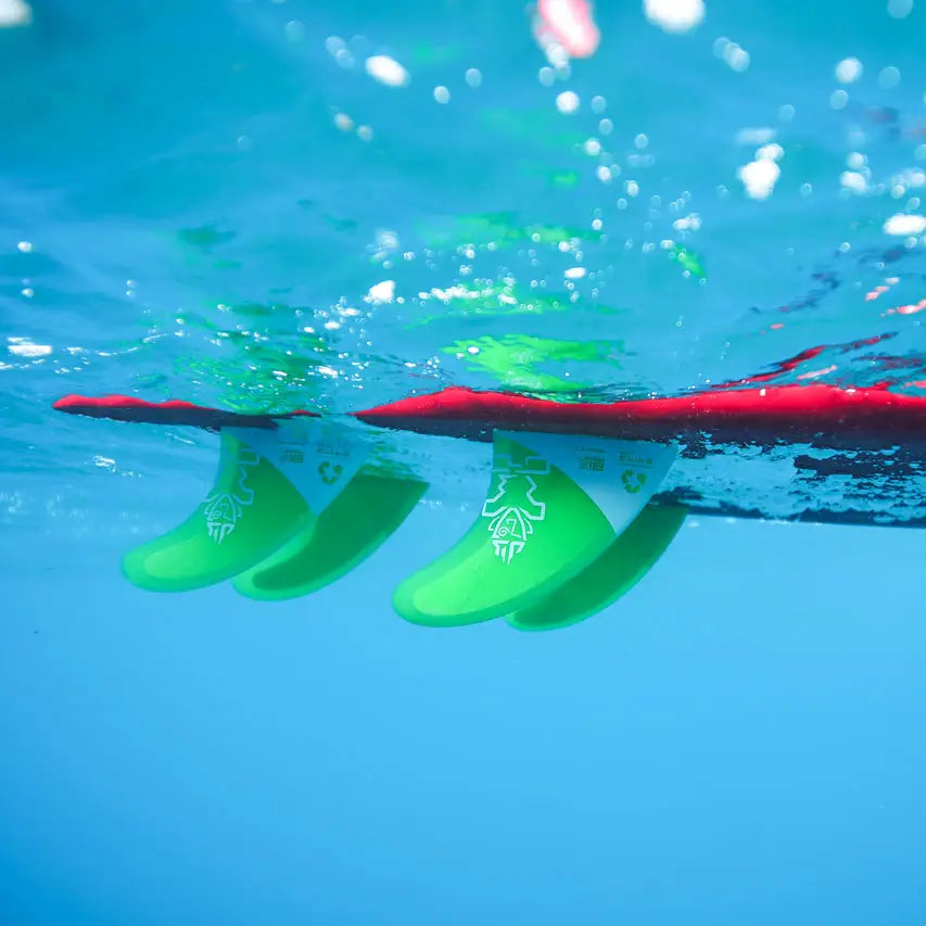Red and green surfboard with fins from SUP Fins and Accessories