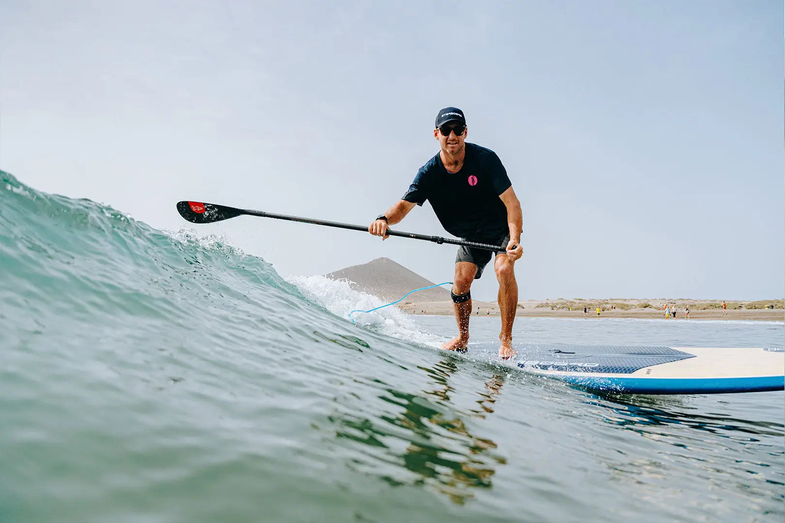 Blue and white SUP paddleboard with red accents, black oar, EVA foam design