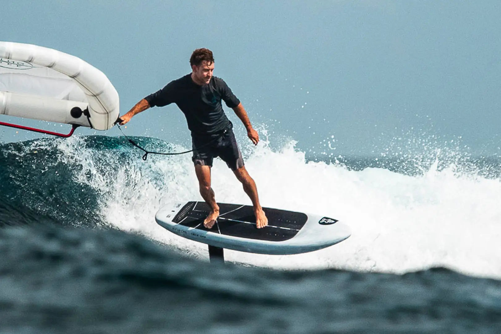 Sleek white and black hydrofoil surfboard with carbon fiber construction from Take Off Foilboards