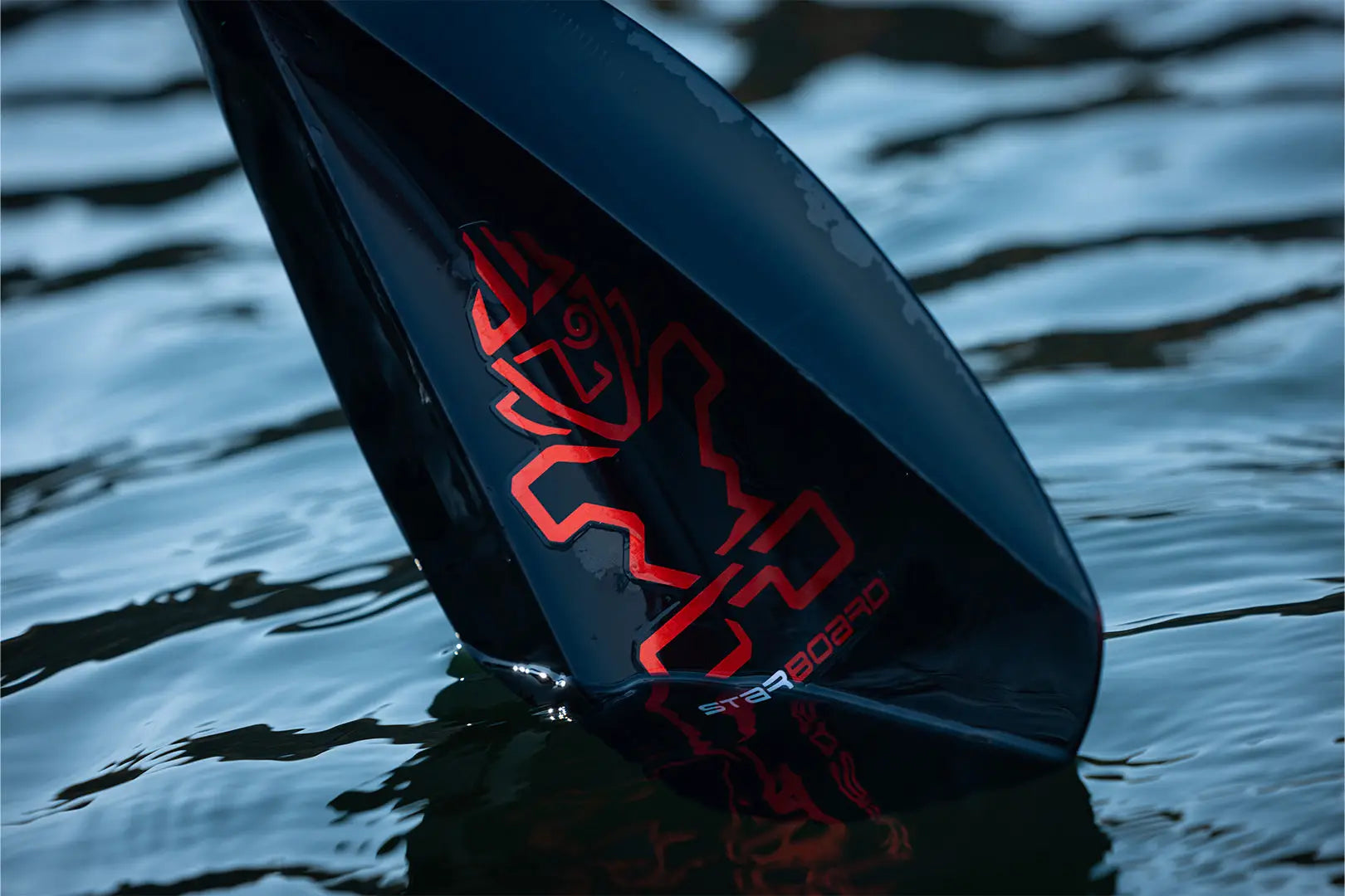 Red and black surfboard fin with unique Tufskin SUP Paddles design