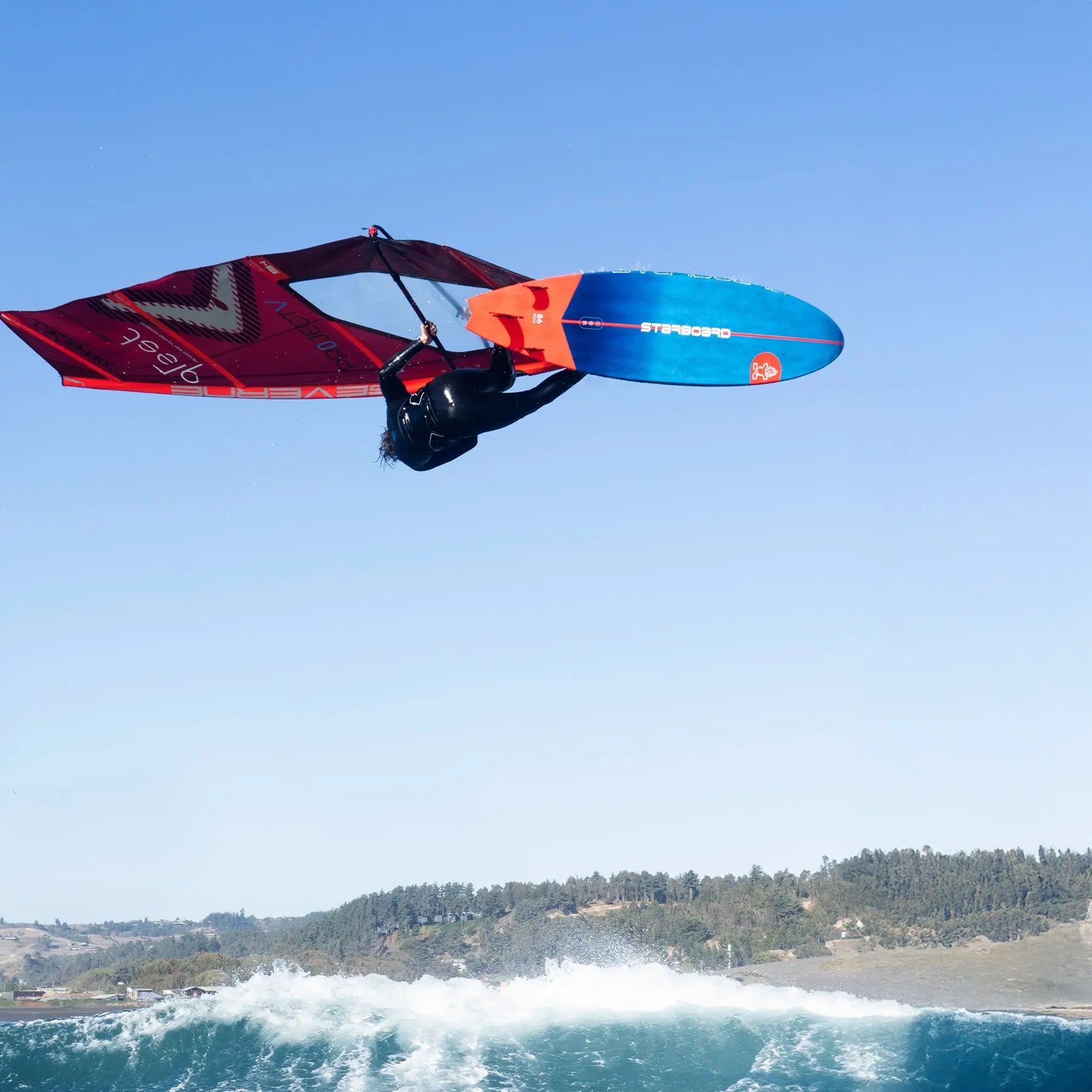 Red and blue surfboard with orange fins for high-performance wave riding in Ultra Windsurf Boards