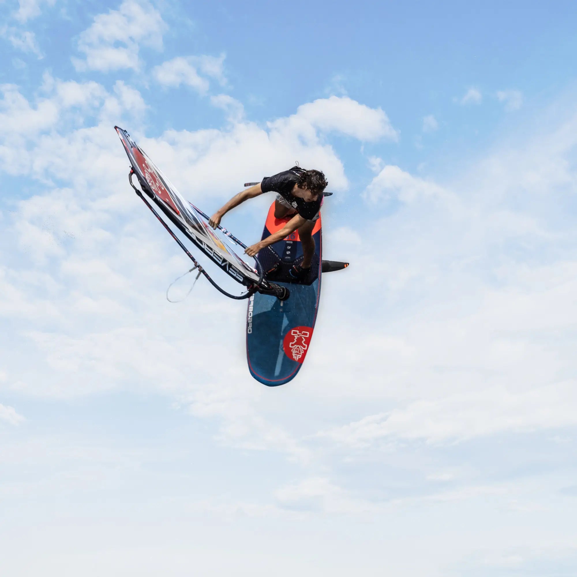 Vibrant blue and red windfoil board with black handlebars and white sail