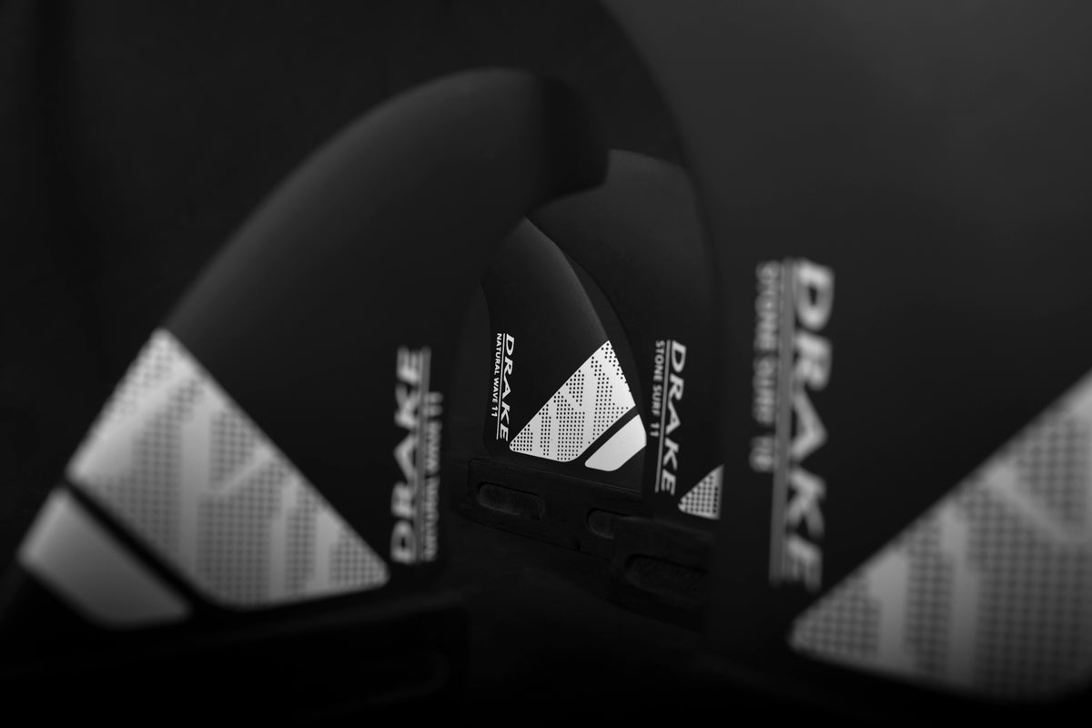 Black and white surfboard with Drake branding in Windsurf Fins collection