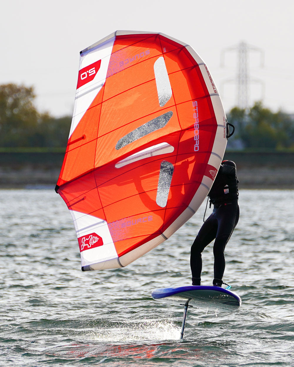 Source Wing vibrant orange and white windsurfing sail with black accents