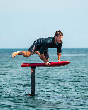 Red Above Foilboard hydrofoil with black fins and silver hardware