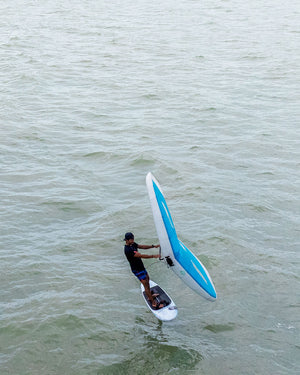 Sleek blue and white Above Foilboard windsurfing board