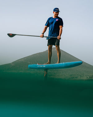 Blue prepreg carbon foil blade paddleboard with black fins, white logo
