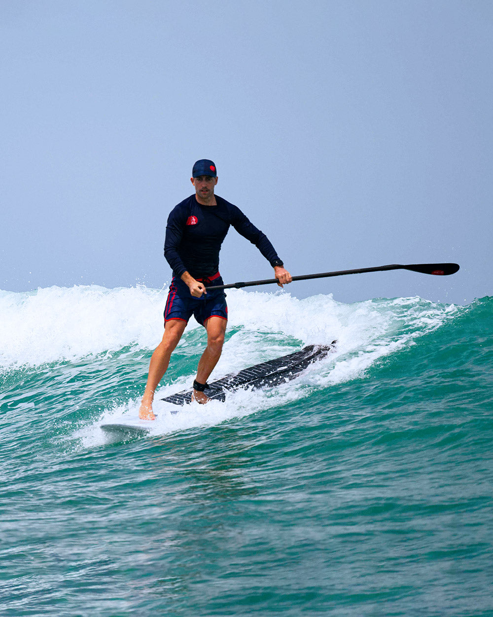Black and white GO Surf Paddleboard with red accents for stand-up paddling