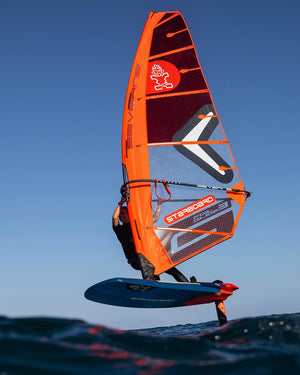Foil FreeRide windfoil board with orange blue design and Starboard red sail