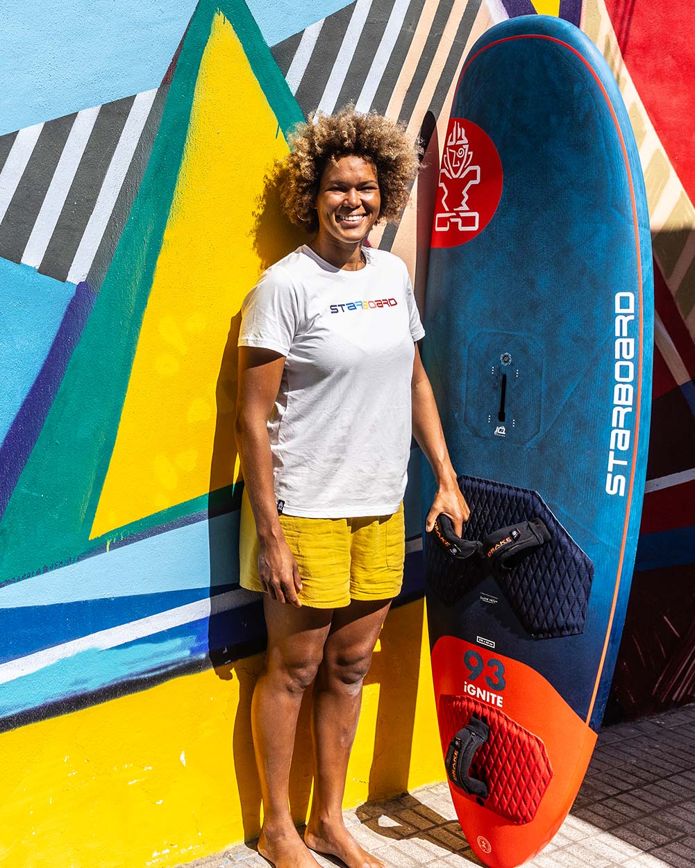 2025 iGNiTE Windsurf Board: blue orange design, black grip, red fins, ocean branding