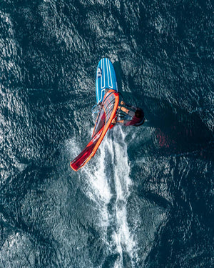 2025 iSonic blue windsurf board with red sail and black handle